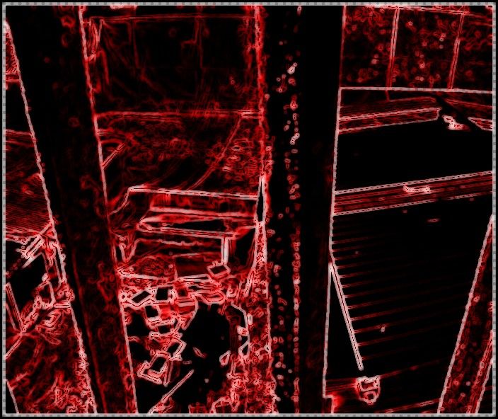 Détection de contours rouge vif sur fond noir : escalier et coursive.